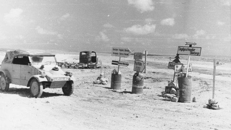 Militärfahrzeug vor Straßenschildern in der Wüste