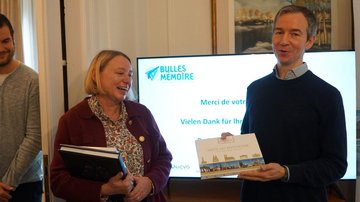 Mann überreicht Frau eine Pralinenpackung