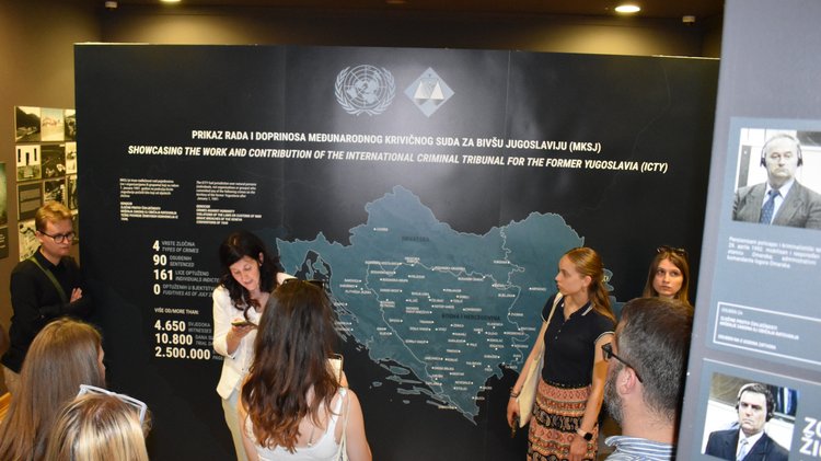 Jugendliche vor einer Ausstellungswand im Rathaus von Sarajevo.