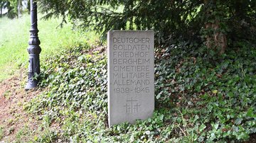 Stein mit Inschrift am Weges- und Waldrand