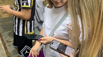 Jugendliche zeigen sich die Angaben auf ihrem Smartphone.