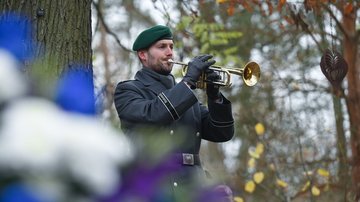 Mann in Uniform spielt Trompete