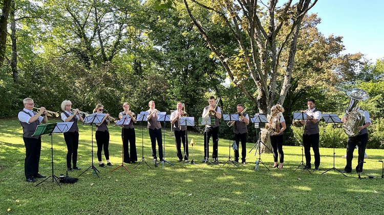 Musiker spielen im Halbkreis auf Blechblasinstrumenten