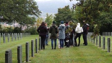 Eine Gruppe steht auf einem Friedhof.