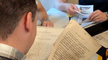 Ein junger Mann liest handschriftliche Briefe.