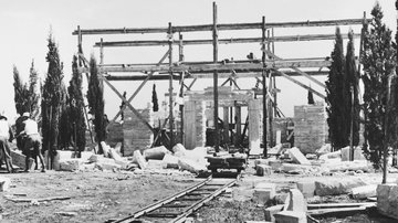 historisches Foto mit halbfertigem Gebäue, Gerüst und Schienen für den Transport der Steine