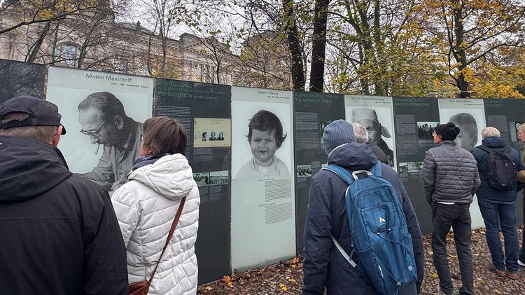 Gruppe von Menschen liest Infotafeln mit Porträts