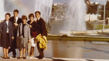 Drei Frauen und zwei Männer stehen vor dem Eiffelturm in Paris.