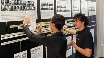 Zwei Jungen stehen vor einer Informationstafel in einem Museum.