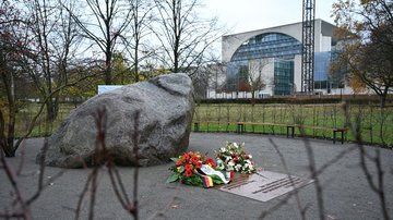 Mahnmal mit großem Stein und Kränzen