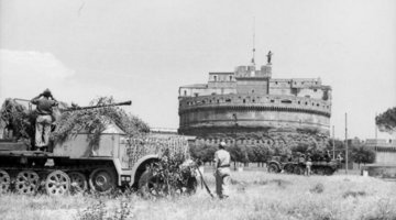 Im Vordergrund ein großes Militärfahrzeug, im Hintergrund ein weiteres, beide stehen vor der Engelsburg