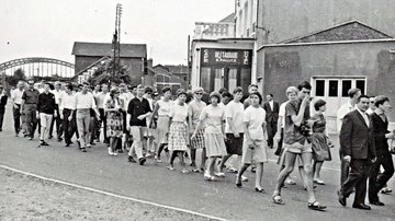 Eine Gruppe junger Menschen marschiert durch einen Ort.